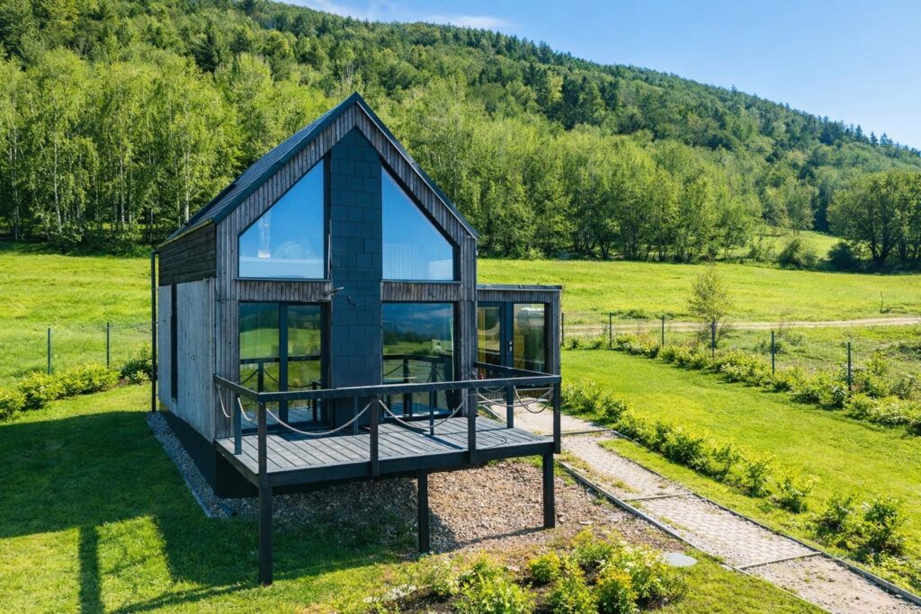 Samsara cottage in Międzygórze surrounded by wildflowers, with the Sudetes mountains behind
