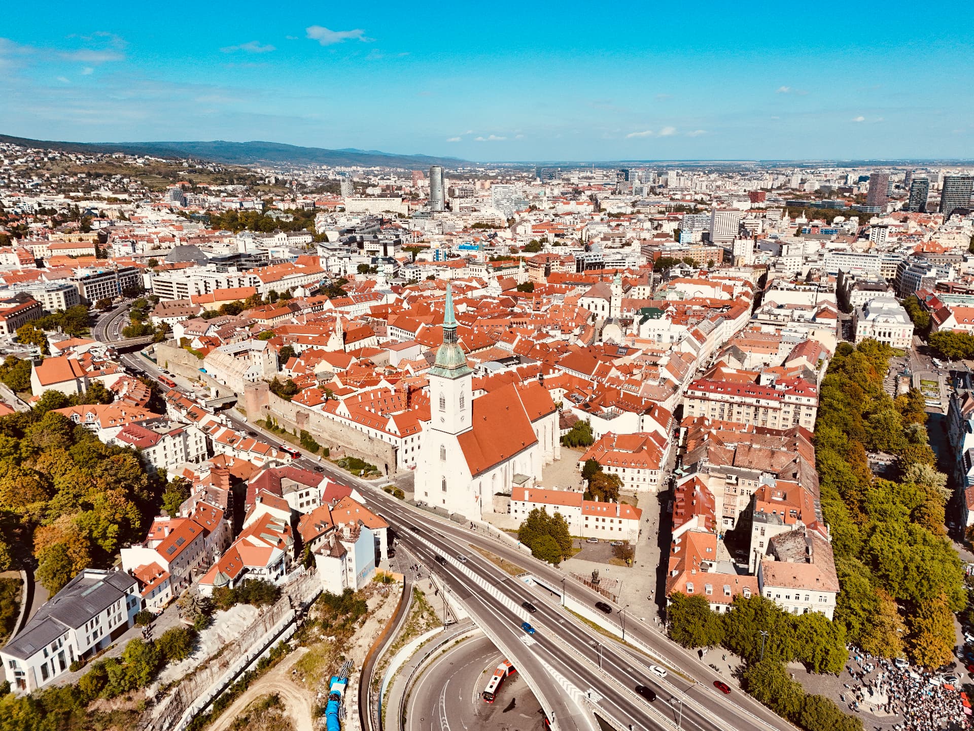 Aerial panorama of Bratislava Old Town with St Martin's Cathedral in the foreground, red tiled roofs, medieval walls and the modern city beyond