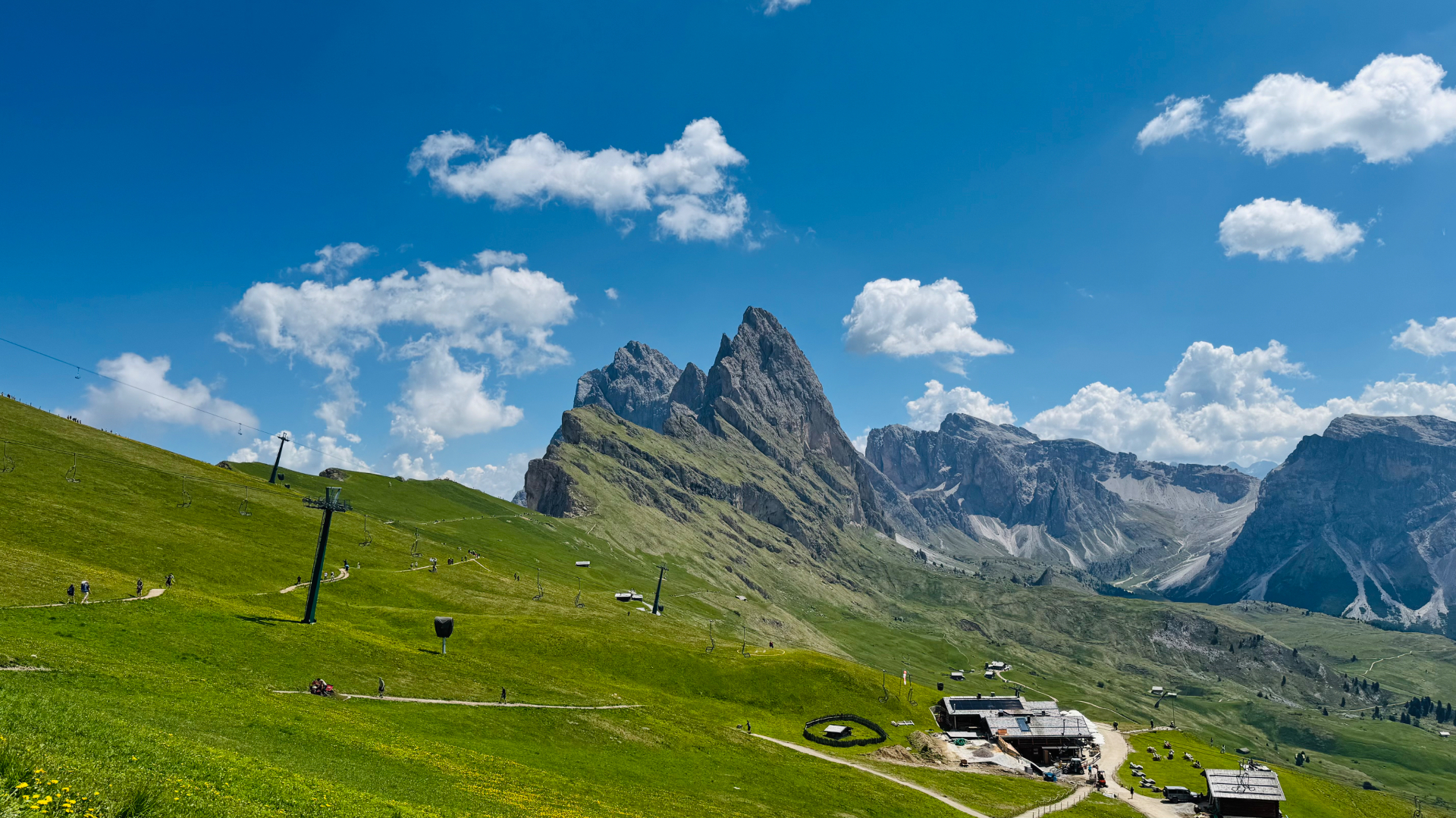 The jagged Seceda ridge rising above green alpine meadows in the Italian Dolomites